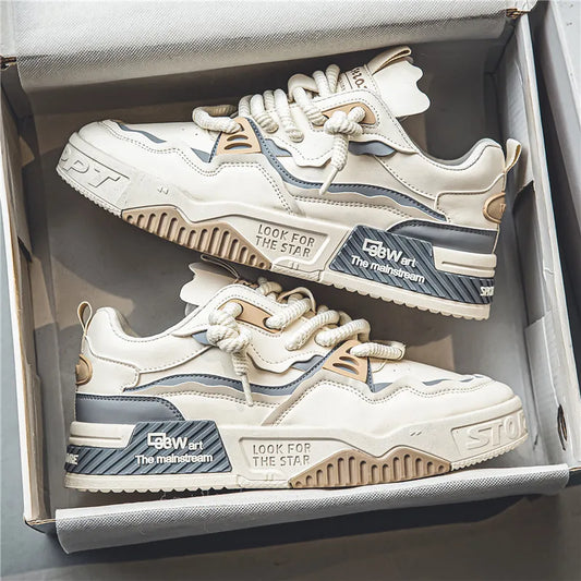 Trendy cream and gray chunky sneakers with bold text accents, thick sole, and rope laces, designed for streetwear lovers and urban fashion enthusiasts.