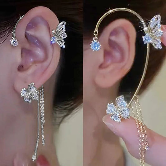 Elegant gold crystal ear cuff for women featuring a curved design with floral rhinestone accents and dangling chain tassels, worn without ear piercing.